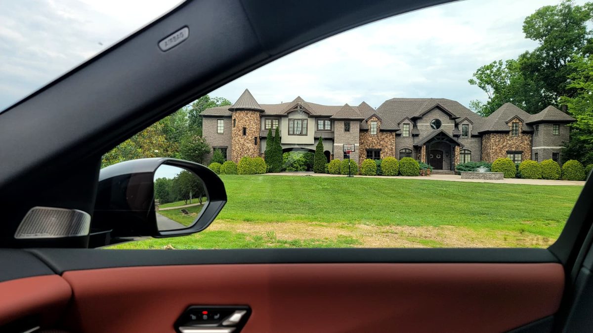 The view from inside a BMW iX3 driving past a brick estate on Almaville Road, Tennessee