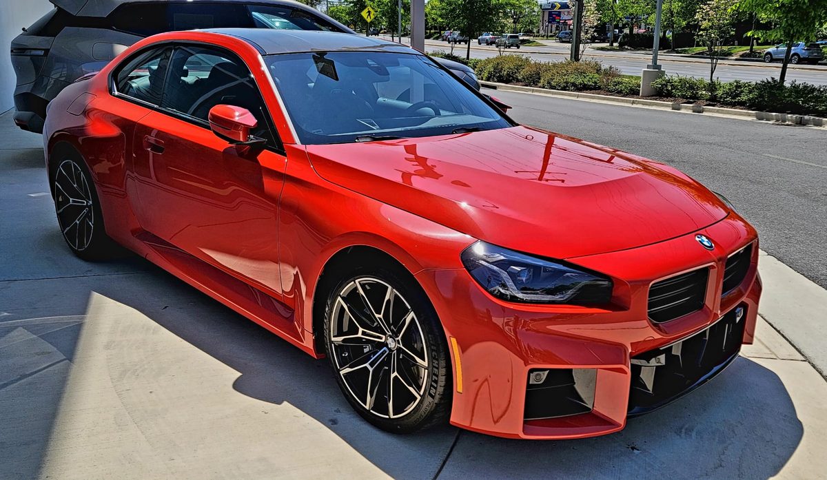 A red BMW 2 Series coupe, representative of the 230i