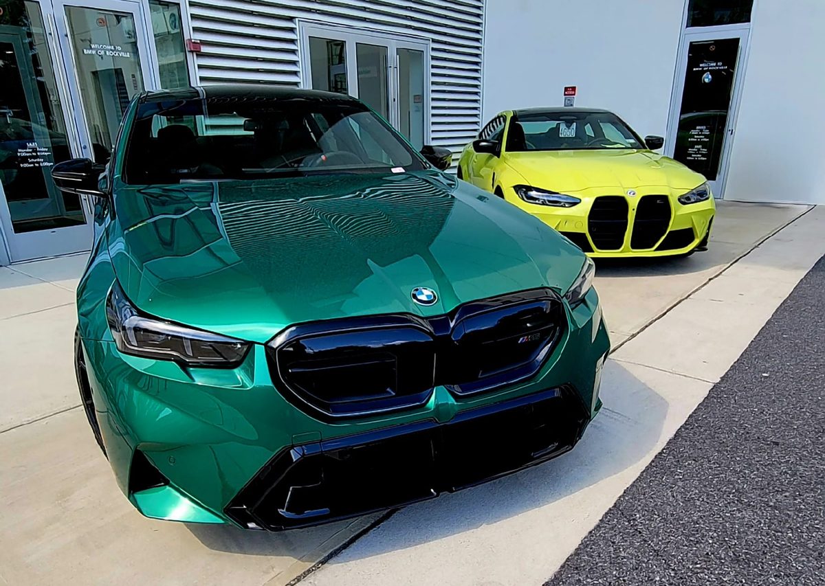 A green BMW M5 and a yellow BMW M4 parked outside BMW of Rockville