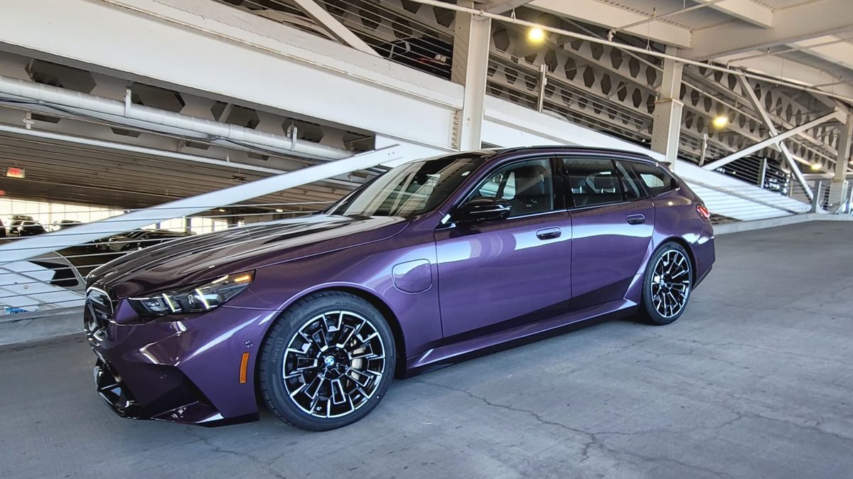 A purple BMW M5 Touring parked in a garage