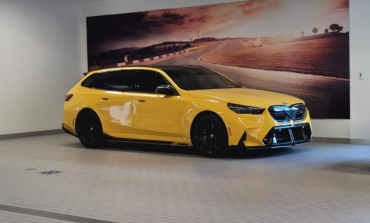 A bright yellow BMW M5 Touring in the BMW of Rockville showroom